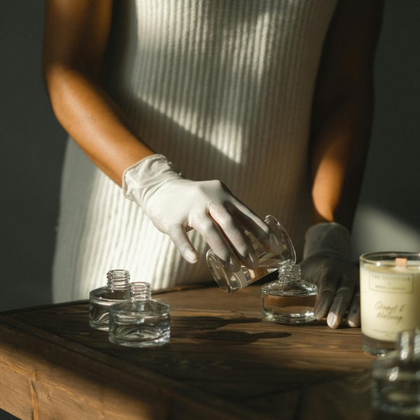 Woman filling a glass jar with candle wax