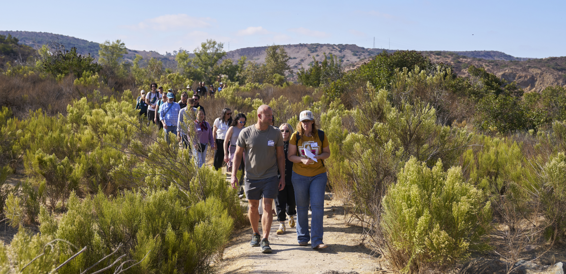 A group of people hike on a mountain trail.