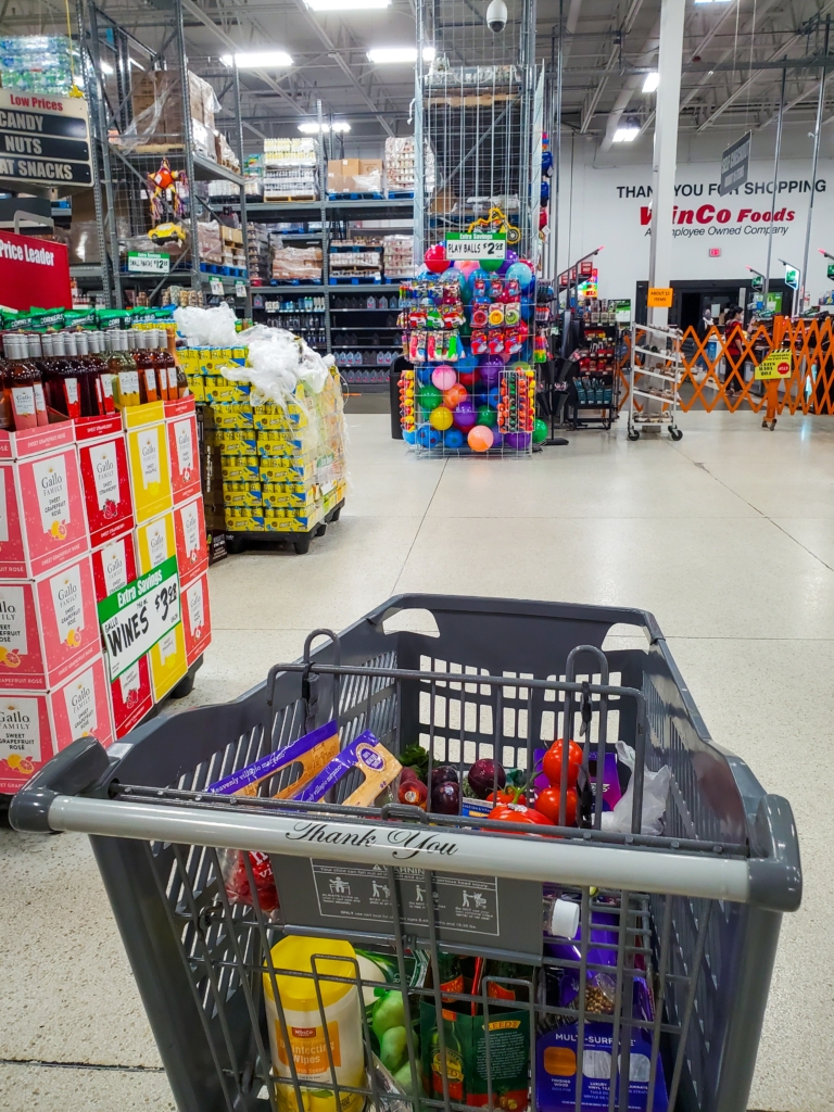 A grocery cart sitting in the aisle of WinCo Foods, an employee-owned company that's top-ranked by NCEO.